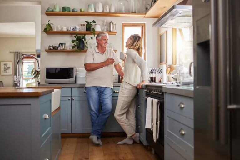 A happy couple enjoy coffee together inside a home they financed with a RetireIt! Mortgage.