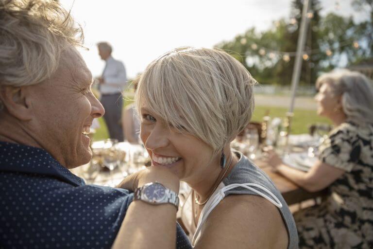 Portrait happy couple enjoying wedding reception at sunny patio table