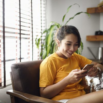 Woman using her smart phone at home Woman using her smart phone at home